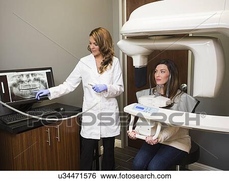 Stock Photograph - Dentist and patient in dentist's office. Fotosearch