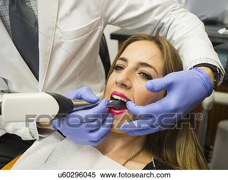Dentist and patient in dentist's office View Large Photo Image Stock Photography - Dentist and patient in dentist's office. Fotosearch