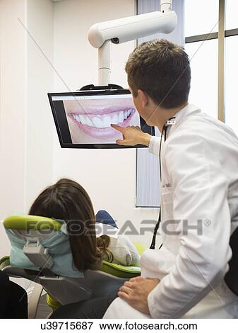 Dentist and patient looking at screen View Large Photo Image Stock Photo - Dentist and patient looking at screen. Fotosearch