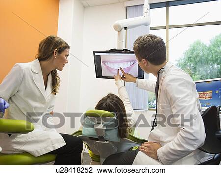 Dentists and patient looking at screen View Large Photo Image Stock Image - Dentists and patient looking at screen. Fotosearch