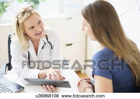 Doctor talking to patient in office View Large Photo Image Stock Photo - Doctor talking to patient in office. Fotosearch