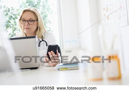 Stock Photo - Doctor working with laptop in her office. Fotosearch