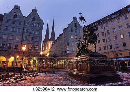 Stock Image - Equestrian statue on illuminated town square . Fotosearch