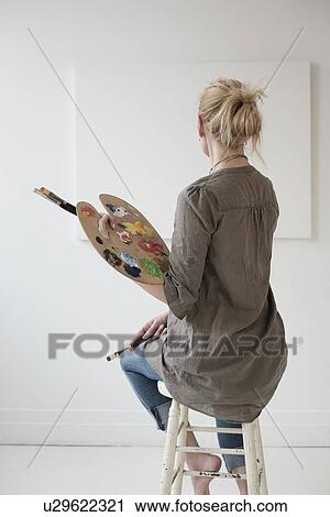 Stock Image - Female artist painting in studio. Fotosearch