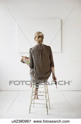 Stock Photo - Female artist painting in studio. Fotosearch