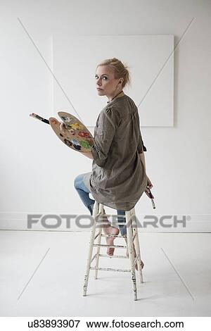 Stock Photo - Female artist painting in studio. Fotosearch