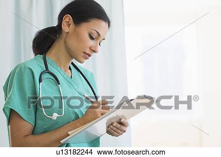 Picture - Female doctor making notes. Fotosearch