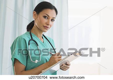 Female doctor making notes View Large Photo Image Picture - Female doctor making notes. Fotosearch