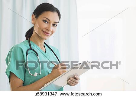 Stock Photo - Female doctor making notes. Fotosearch