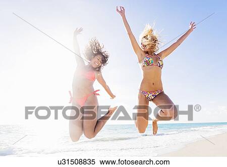 Female friends jumping on beach View Large Photo Image Stock Photography - Female friends jumping on beach. Fotosearch