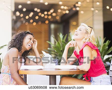 Female friends laughing in street cafe View Large Photo Image Stock Photo - Female friends laughing in street cafe. Fotosearch