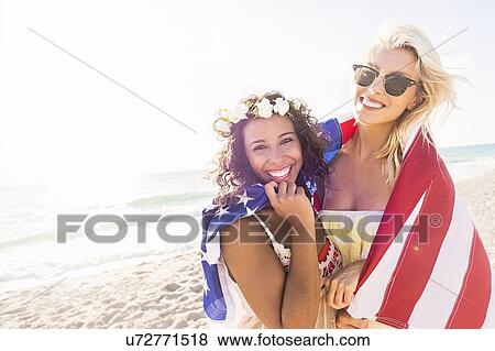 Female friends on beach with American flag View Large Photo Image Stock Photo - Female friends on beach with American flag. Fotosearch