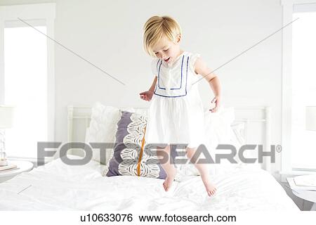 Girl (2-3) jumping on bed View Large Photo Image Stock Photograph - Girl (2-3) jumping on bed. Fotosearch