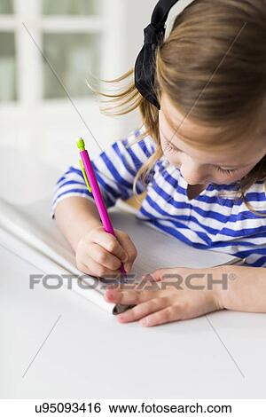 Stock Photograph - Girl (4-5) drawing in living room. Fotosearch