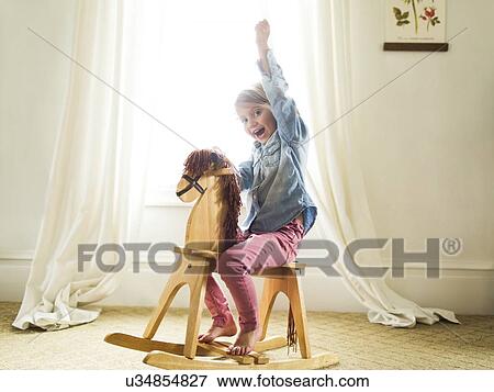 Girl (4-5)on rocking horse View Large Photo Image Stock Photo - Girl (4-5)on rocking horse. Fotosearch