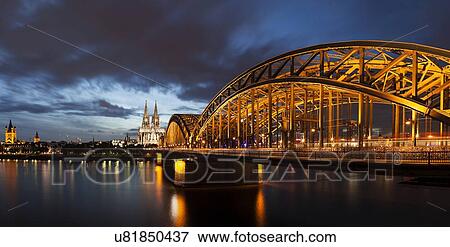 Stock Photo - Hohenzollern Bridge illuminated at dusk. Fotosearch