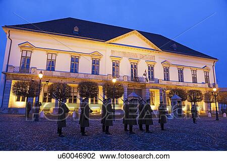 Stock Image - Honor guard in front of illuminated Sandor Palace. Fotosearch