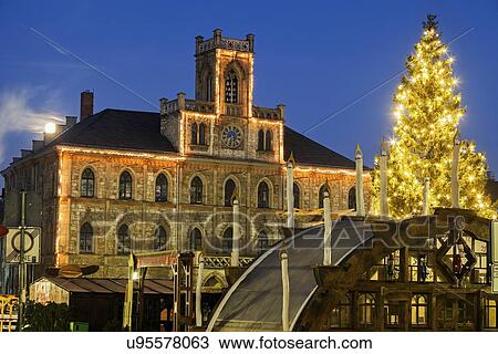 Stock Image - Illuminated Christmas tree and town hall. Fotosearch