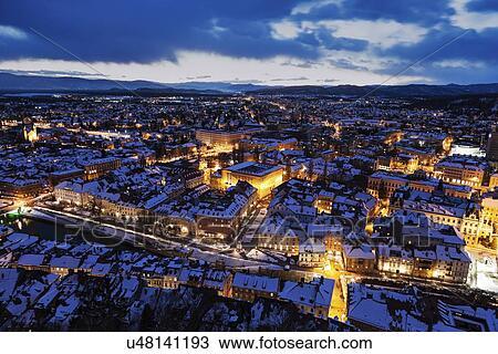Stock Image - Illuminated cityscape at dusk. Fotosearch