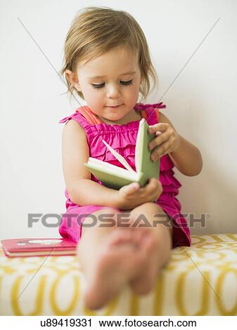 Little girl (2-3) holding book View Large Photo Image Stock Image - Little girl (2-3) holding book. Fotosearch