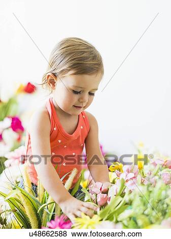 Stock Photo - Little girl (2-3) playing with flowers. Fotosearch