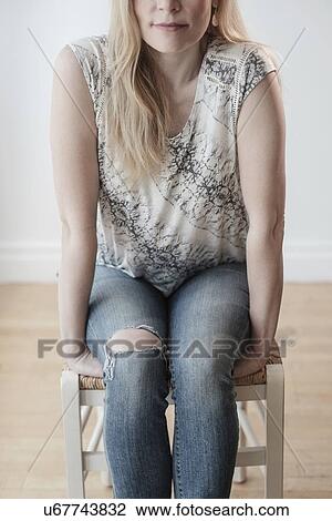 Stock Image - Low-section of woman wearing torn jeans. Fotosearch