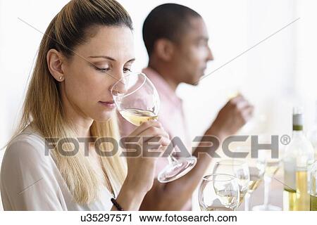 Stock Image - Man and woman tasting white wine. Fotosearch