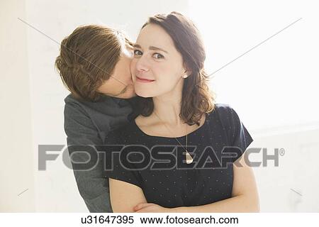 Stock Photography - Man kissing smiling young woman. Fotosearch