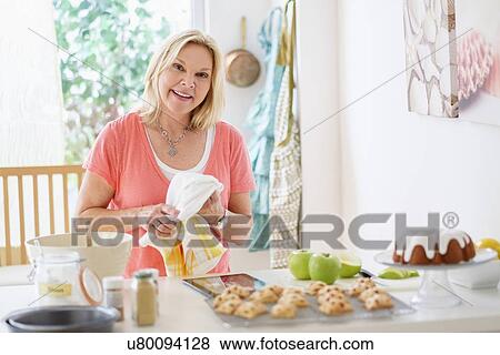 Mature woman baking in kitchen View Large Photo Image Stock Photo - Mature woman baking in kitchen. Fotosearch