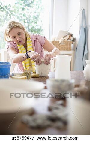 Mature woman making pottery in studio View Large Photo Image Stock Photo - Mature woman making pottery in studio. Fotosearch