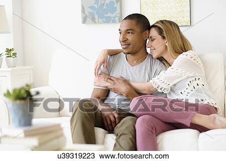 Mid adult couple embracing in living room View Large Photo Image Stock Image - Mid adult couple embracing in living room. Fotosearch