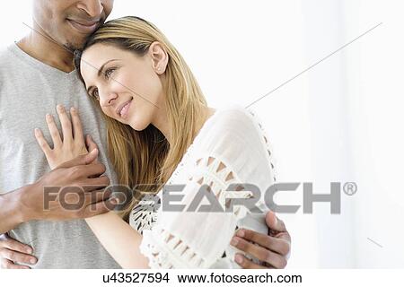 Picture - Mid adult couple embracing. Fotosearch