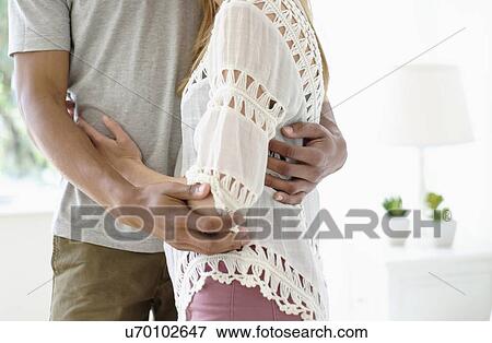 Stock Photo - Mid adult couple embracing. Fotosearch