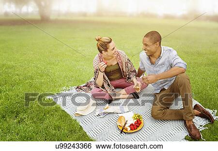 Mid adult couple having picnic in park View Large Photo Image Stock Photograph - Mid adult couple having picnic in park. Fotosearch