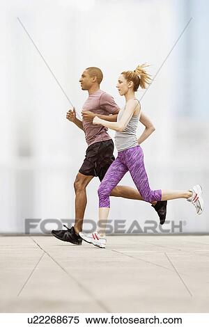 Stock Photography - Mid adult couple running. Fotosearch