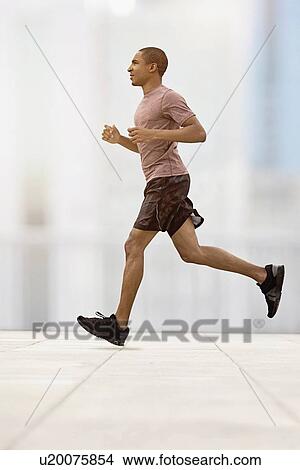 Picture - Mid adult man running. Fotosearch