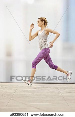 Stock Image - Mid adult woman running. Fotosearch