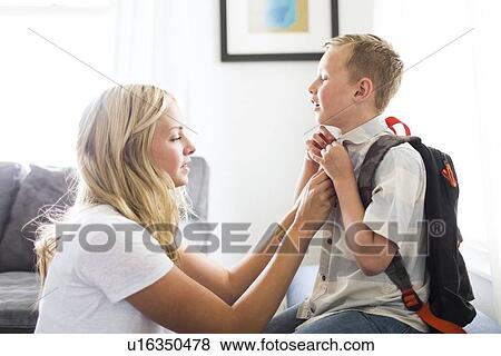 Mother helping son (6-7) buttoning shirt View Large Photo Image Stock Photo - Mother helping son (6-7) buttoning shirt. Fotosearch