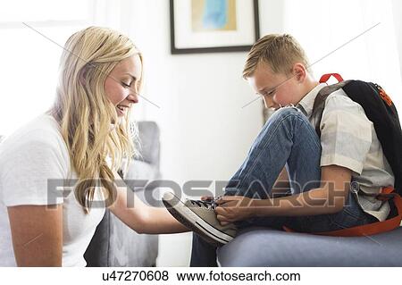 Mother helping son (6-7) tying shoes View Large Photo Image Stock Photo - Mother helping son (6-7) tying shoes. Fotosearch