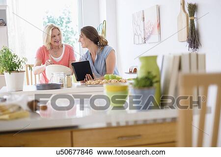 Mother with adult daughter baking in kitchen View Large Photo Image Stock Photograph - Mother with adult daughter baking in kitchen. Fotosearch