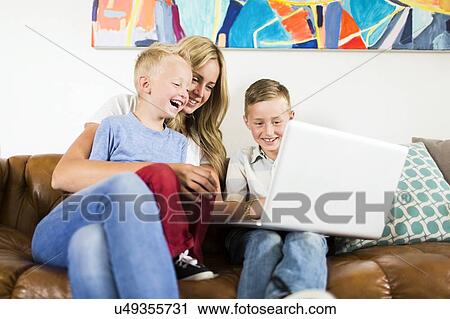 Mother with children (4-5, 6-7) using laptop on sofa View Large Photo Image Stock Image - Mother with children (4-5, 6-7) using laptop on sofa. Fotosearch