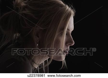 Stock Image - Portrait of blond woman in studio. Fotosearch