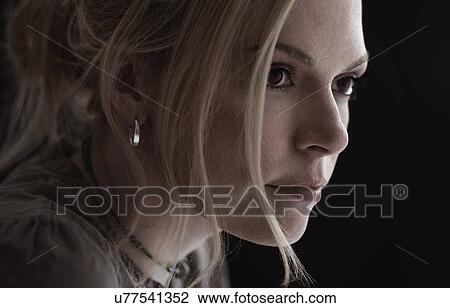 Stock Image - Portrait of blond woman in studio. Fotosearch