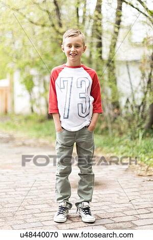Portrait of boy (6-7) standing on sidewalk View Large Photo Image Stock Image - Portrait of boy (6-7) standing on sidewalk. Fotosearch