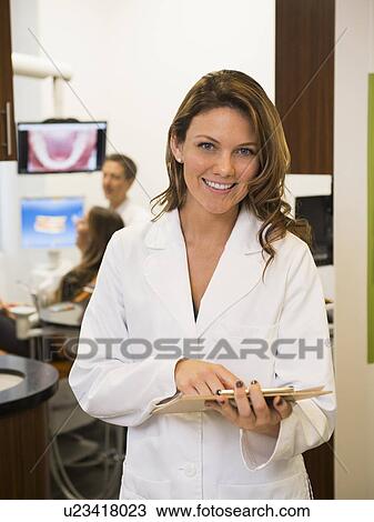Portrait of dentist with colleague and patient in background View Large Photo Image Stock Image - Portrait of dentist with colleague and patient in background. Fotosearch