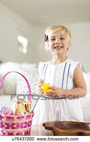 Stock Image - Portrait of girl (2-3) holding candy. Fotosearch