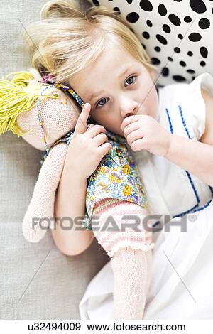 Stock Photo - Portrait of girl (2-3) relaxing on sofa. Fotosearch