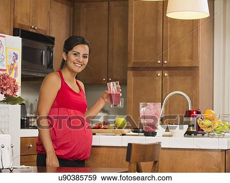 Stock Photo - Portrait of pregnant woman with fruit cocktail. Fotosearch