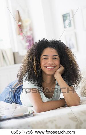 Portrait of teenage girl (16-17) lying on bed View Large Photo Image Stock Photograph - Portrait of teenage girl (16-17) lying on bed. Fotosearch