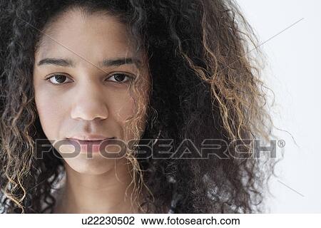 Stock Image - Portrait of teenage girl (16-17) on white background. Fotosearch